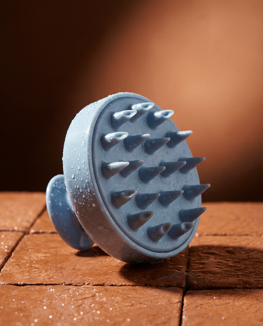Blue silicone brush with textured surface on a wooden surface