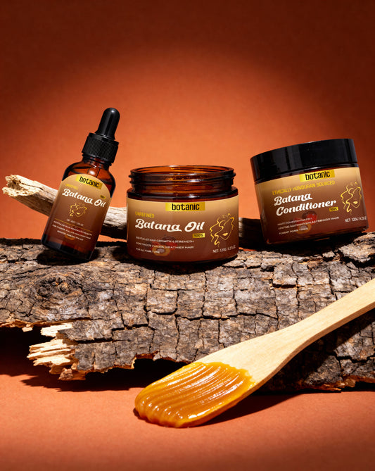 Batana Oil and Conditioner products on a wooden surface with a warm background